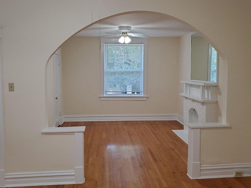 View of the front two room with hardwood floors, archway, ceiling fans