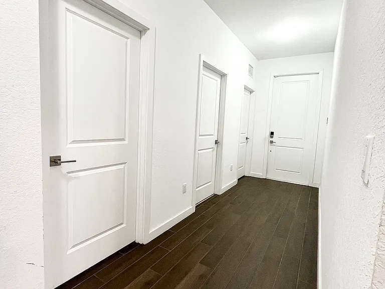 Hallway by the front door leads to bedrooms 2 & 3, the flex room, a bathroom, and the garage.