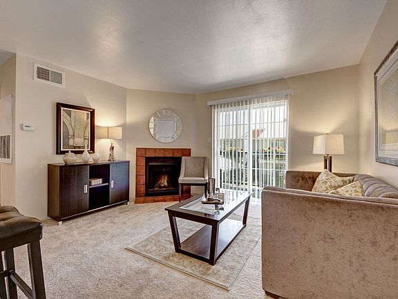 A living room with fireplace and sliding glass door out to the patio