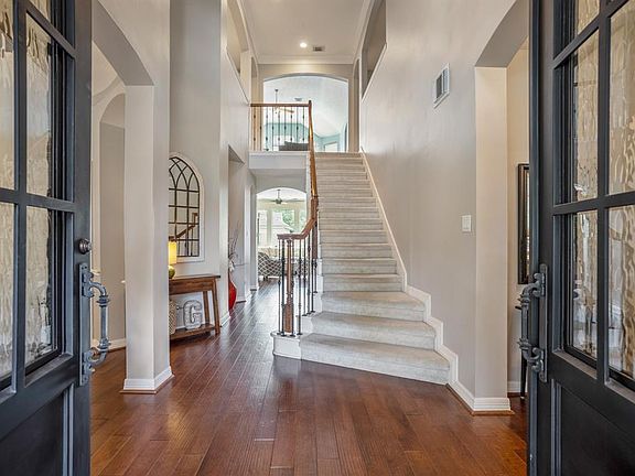 Imposing double wrought iron and glass front doors lead into your incredible new home.