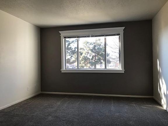 Large living room with gorgeous window molding highlighted by lovely accent wall & beautiful views.