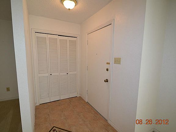 Elegant entry with tile flooring and storage closet.