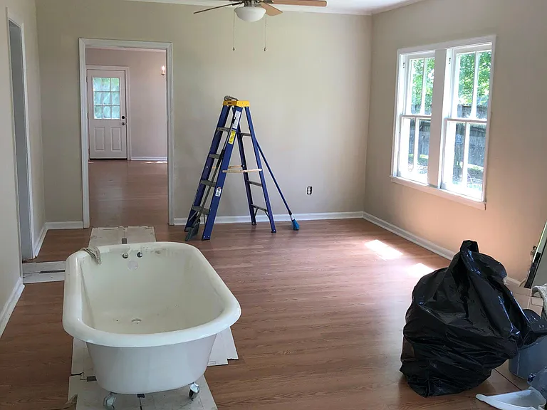 Huge living room with brand new floors, paint and ceiling fans and lots of light.