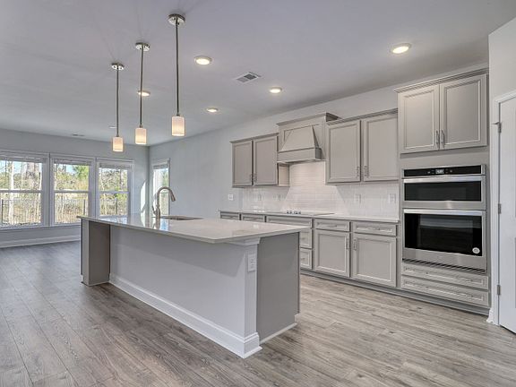 Gorgeous Kitchen with large island, gray cabinets and an wall oven.