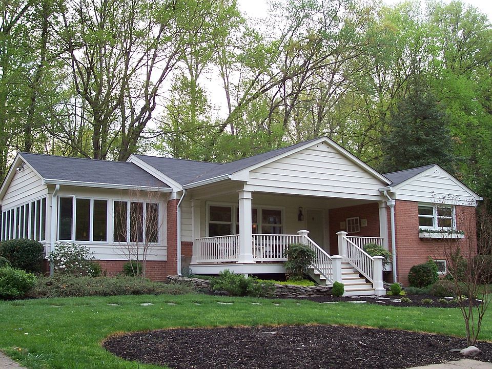Front with beautiful landscaping and custom crafted front porch