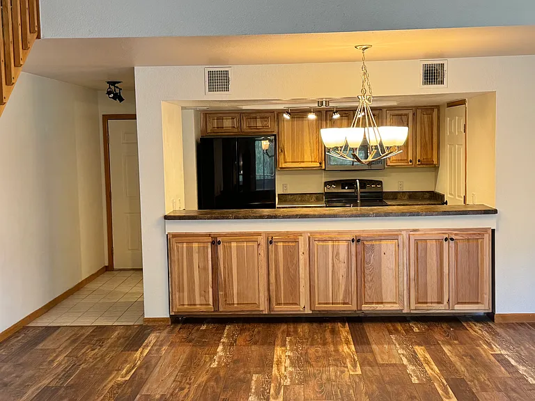 Open main living area with vaulted volume, fireplace, loft access, and an easy flow between the kitchen, dining, and gathering spaces.