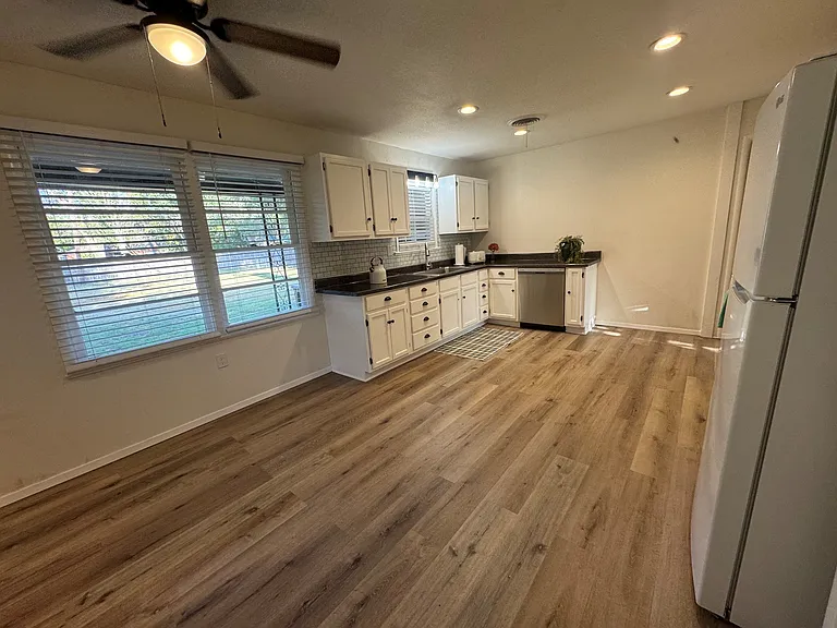 Kitchen is aprox 17.25'x12.75'. Includes gas stove, fridge, DW, countertop MW/airfryer/convection. Area for table/chairs and door to patio.