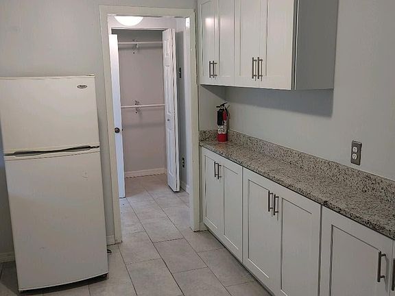 Similar view of kitchen showing the cabintes also along the north wall.