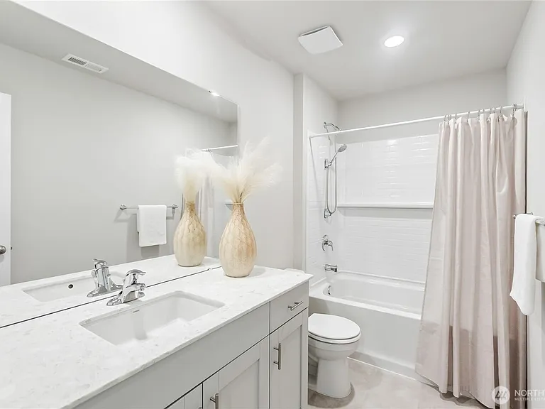 Upper stair bathroom with white cabinet and quartz countertops.