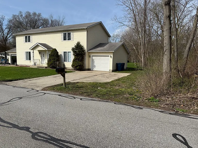 Side of property showing driveway and sideyard backing up to Walking Trail