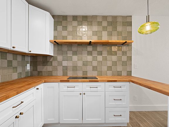 Brand new beautiful kitchen! Complete with butcher block countertops, farmhouse sink, new induction cooktop stove, stacked washer and dryer, new cabinets, and stylish backsplash!