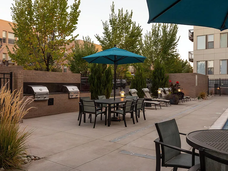 Outdoor Grilling Area with Shade Umbrellas and Dining Tables