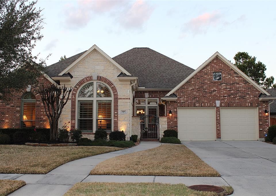 Gorgeous one story home. This beautiful front view of the home shows handsome stone & brick front and three car garage (includes one tandem garage spot). Notice double car driveway and lush landscaping. Lovely courtyard will greet you as you step thr