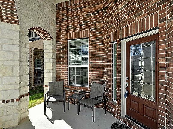 So welcoming and friendly. Lovely covered front porch with stone columns.