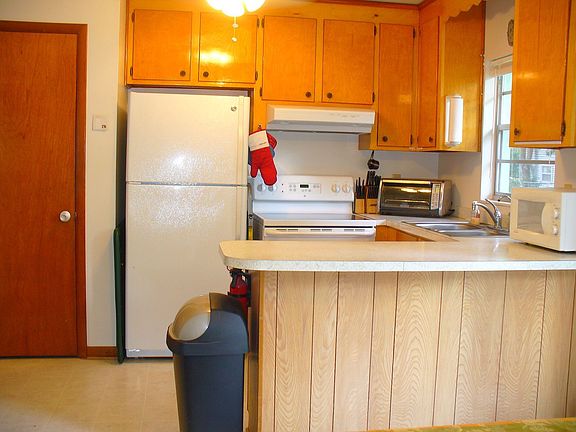 Kitchen with pantry, newer fridge and flat top stove