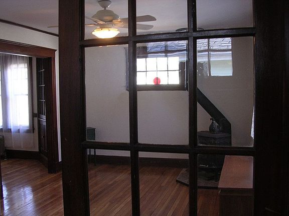 French doors separate the foyer from the living room with wood stove.