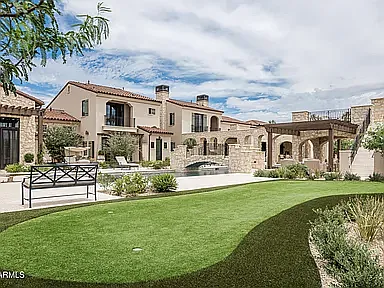 Impressive rear view of the estate showcasing lush landscaping, open green space, and refined outdoor design.