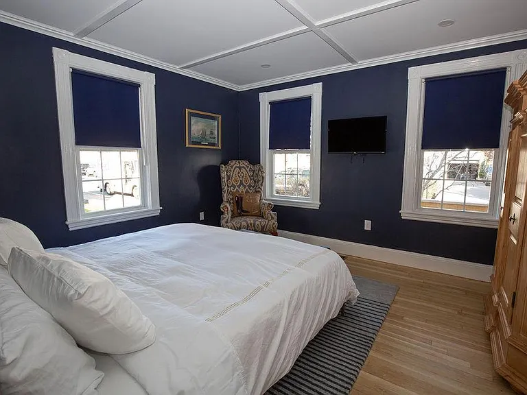 King bedroom faces quiet street and front porch with two rocking chairs