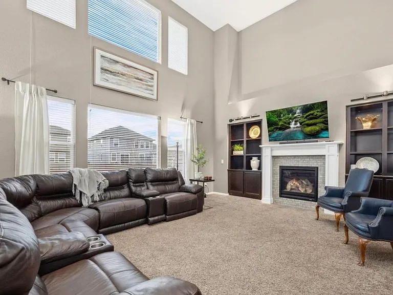 Living room with enormous windows that let in so much light. There are blinds on windows to filter light if needed