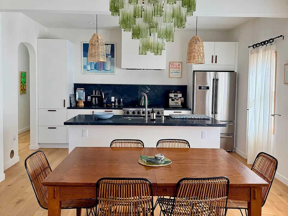 The open-layout dining room table seats 6, or 8 when extended. Also features a Sonos speaker.