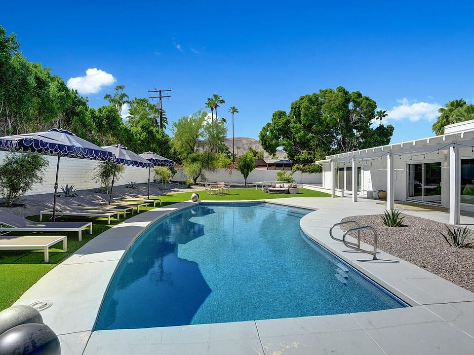pebble tech pool , 6 sun chaises , umbrellas ,dining table and several seating areas .