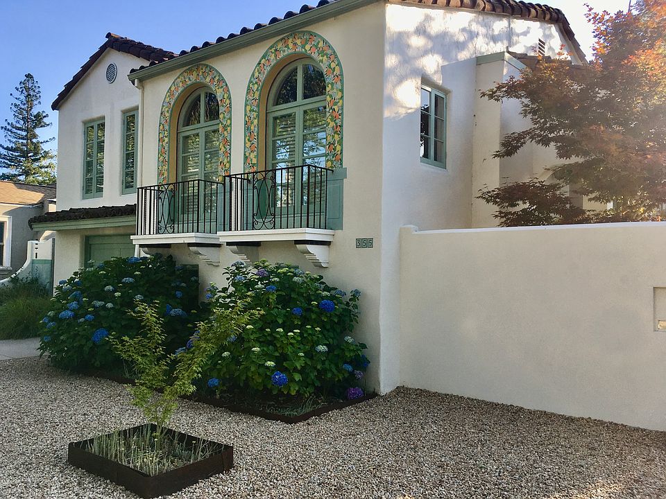 Charming facade of historic home, with decorative painted bands of oranges, lemons and almonds around arched windows. Your separate entrance is to the left, on a flat landscaped aflagstone patio with antique wooden gates.