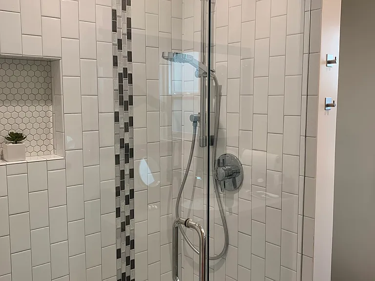 Unit 11 white subway tiled shower with handheld shower head