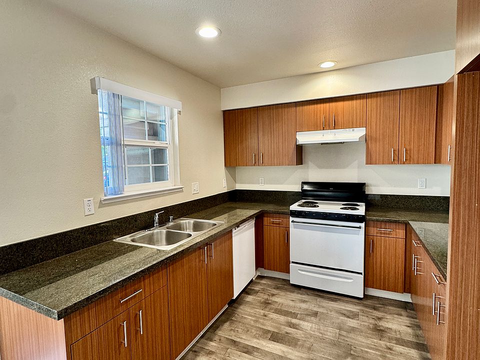Kitchen with ample counter space and storage. Dishwasher, garbage disposal, electric range, and refrigerator all included.