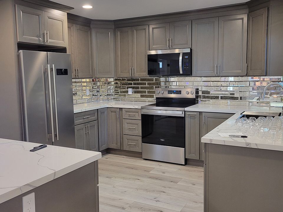 Newly installed kitchen cabinetry with new appliances, tile, granite countertops, and LVT floor throughout the home.