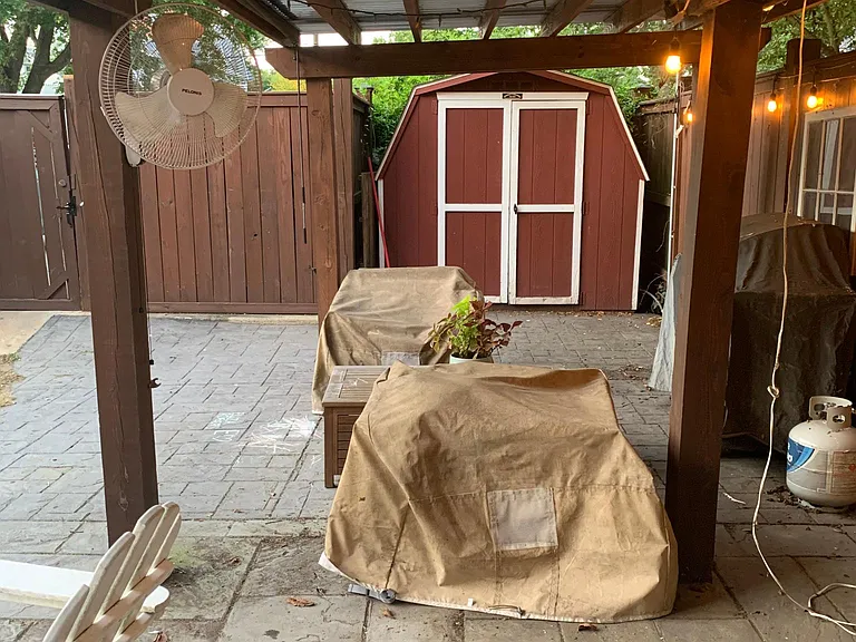Covered and hardscaped patio withing fenced-in back yard
