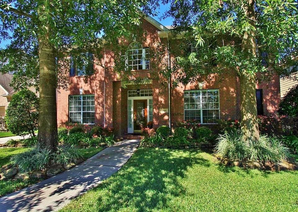 Majestic trees and mature landscaping frame this picturesque 5 Bedroom Home that features an open co