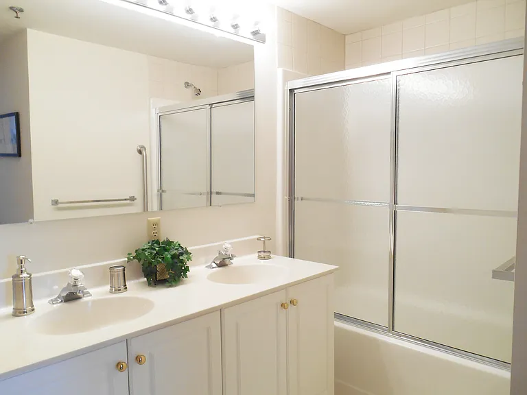 Primary bath with either tub and shower enclosure or walk in shower and one or two sinks. White cabinetry.