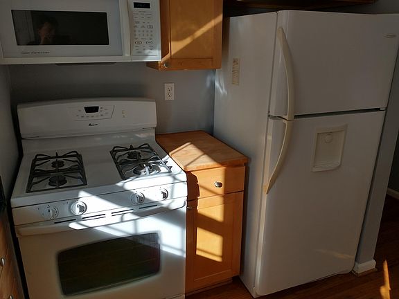 Kitchen showing gas stove, microwave, refrigerator