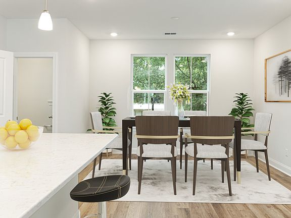 Island kitchen dining area with 2 large windows in a DRB Homes Brookgreen model home at the Park C