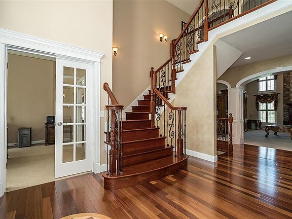 Decorative Baluster stairway with Wood treads and Sconce lighting. French Door Office Entrance and Special Millwork and Moldings throughout.