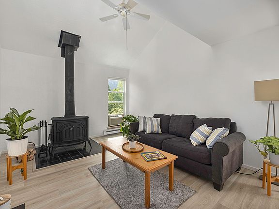 The spacious living room with its high ceiling and wood burning stove makes for a bright but cosy place.