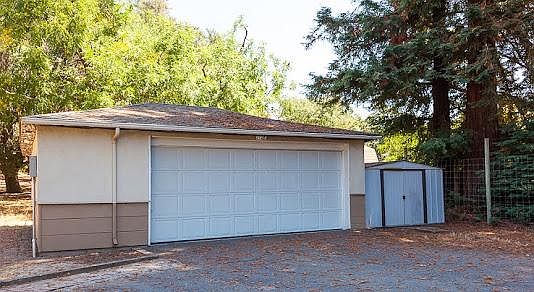 Detached garage with storage and extra refrigerator.