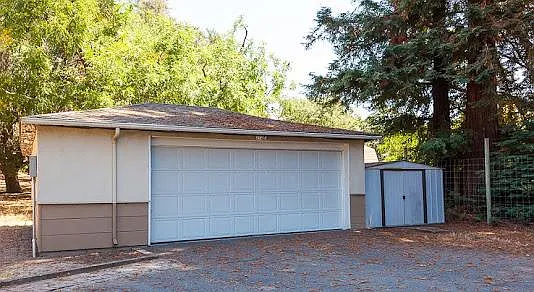 Detached garage with storage and extra refrigerator.