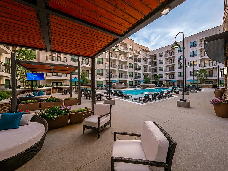 Expansive outdoor community space features lounge areas with large screen TVs