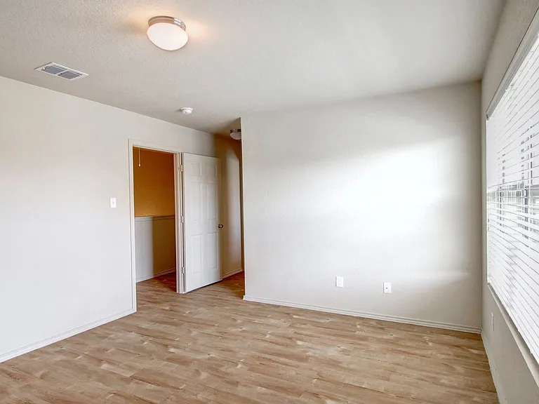 Bright, airy room with wooden flooring, neutral walls, and a large window inviting natural light. Bright, airy room with wooden flooring, neutral walls, and a large window inviting natural light.