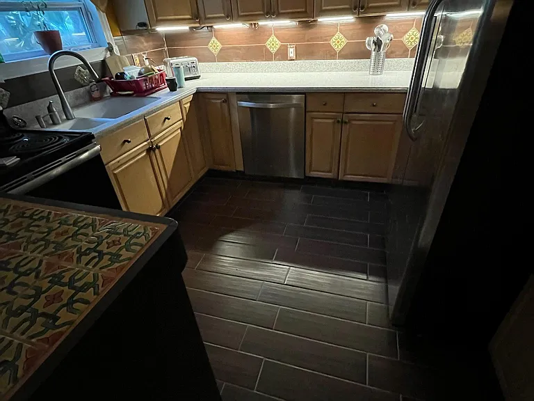 Kitchen and tiled island between kitchen and dining room.