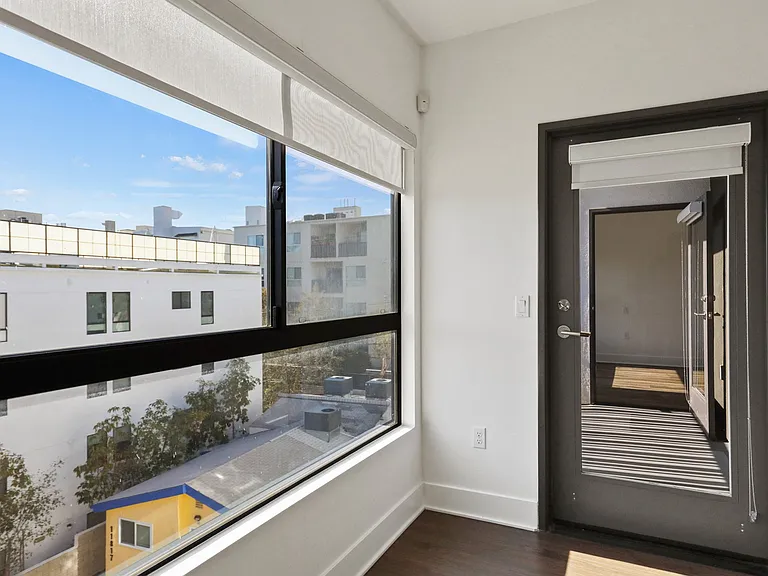 Living Room with Large Windows with Shades and Patio