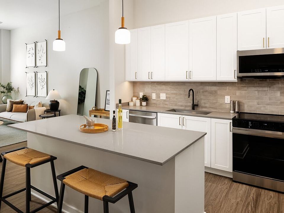 Design Collection I kitchen with stainless steel appliances, grey quartz countertops, white cabinetry, and hard surface flooring