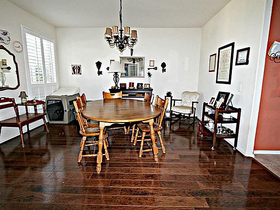 ENTERTAIN YOUR GUESTS IN UNCROWDED COMFORT IN THIS FORMAL DINING ROOM FEATURING PLANTATION SHUTTERS, ROUNDED CORNERS, AND HARDWOOD FLOOR