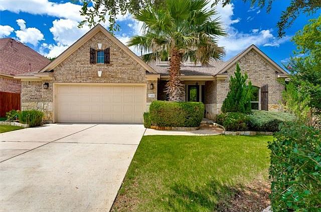 Front of home with gorgeous landscaping.