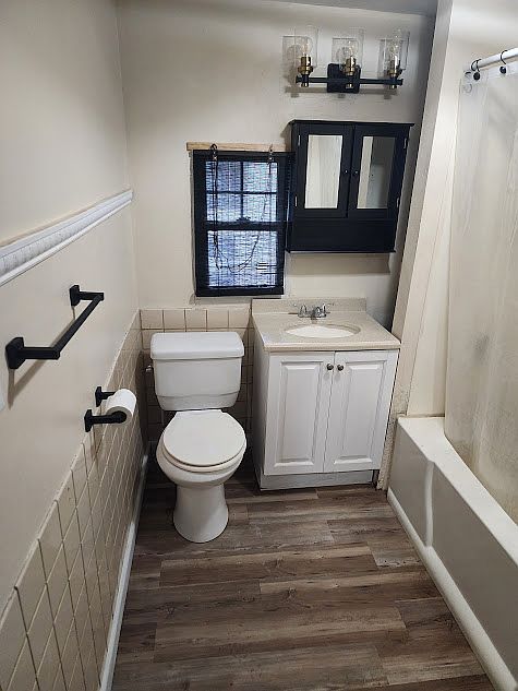 Main bathroom with new window treatments, flooring and lighting fixtures and more.