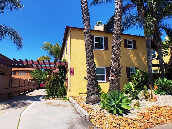 Carefully landscaped succulent garden flanked by regal palms provides captivating curb appeal.