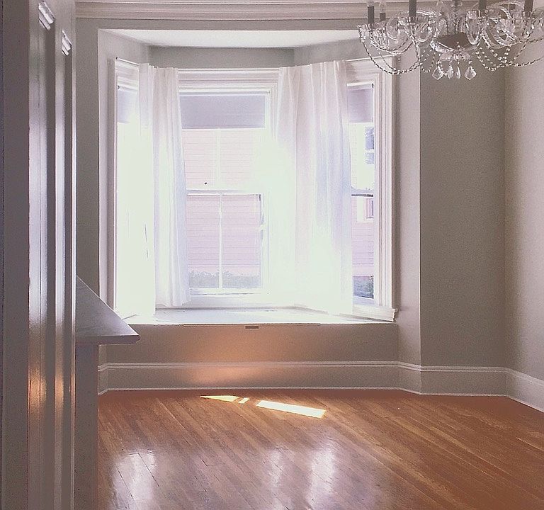 The "middle" room also has old world character with a large bay window and high ceilings, and original plaster crown moulding and ceiling medallion. Before move in, the walls will be repainted Ben Moore Simply White.