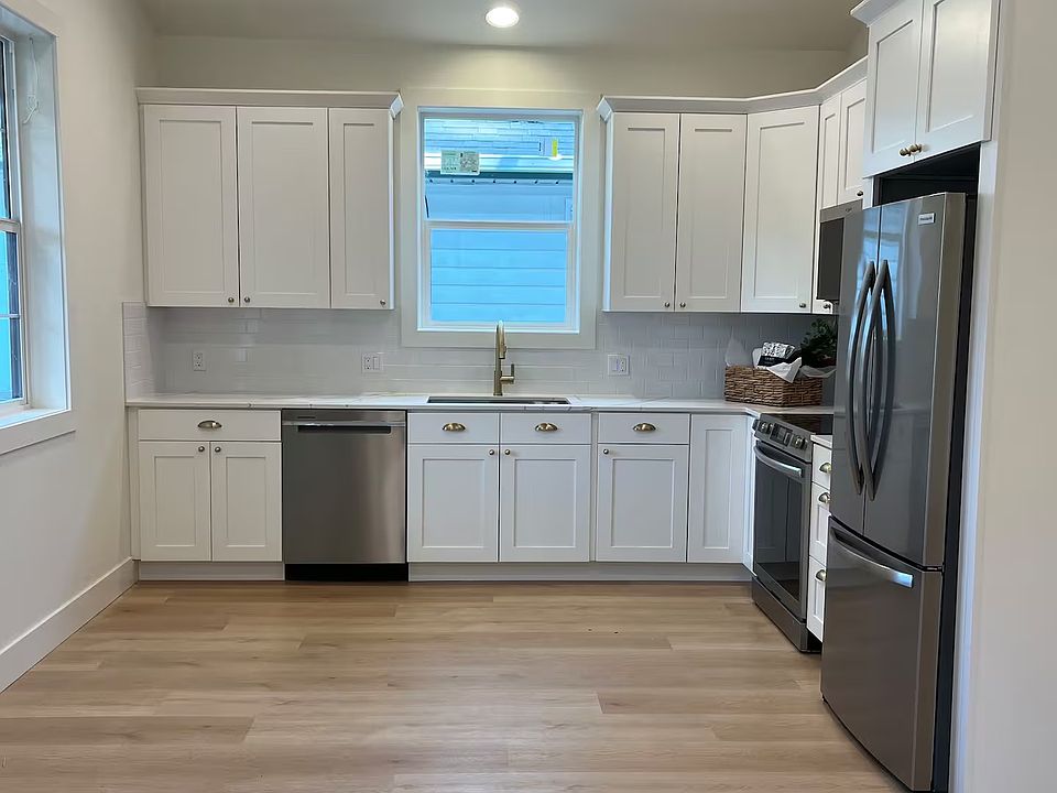 Full kitchen with modern stainless steel appliances - including dishwasher and fridge.