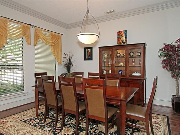 Formal dining room with hardwood floors.